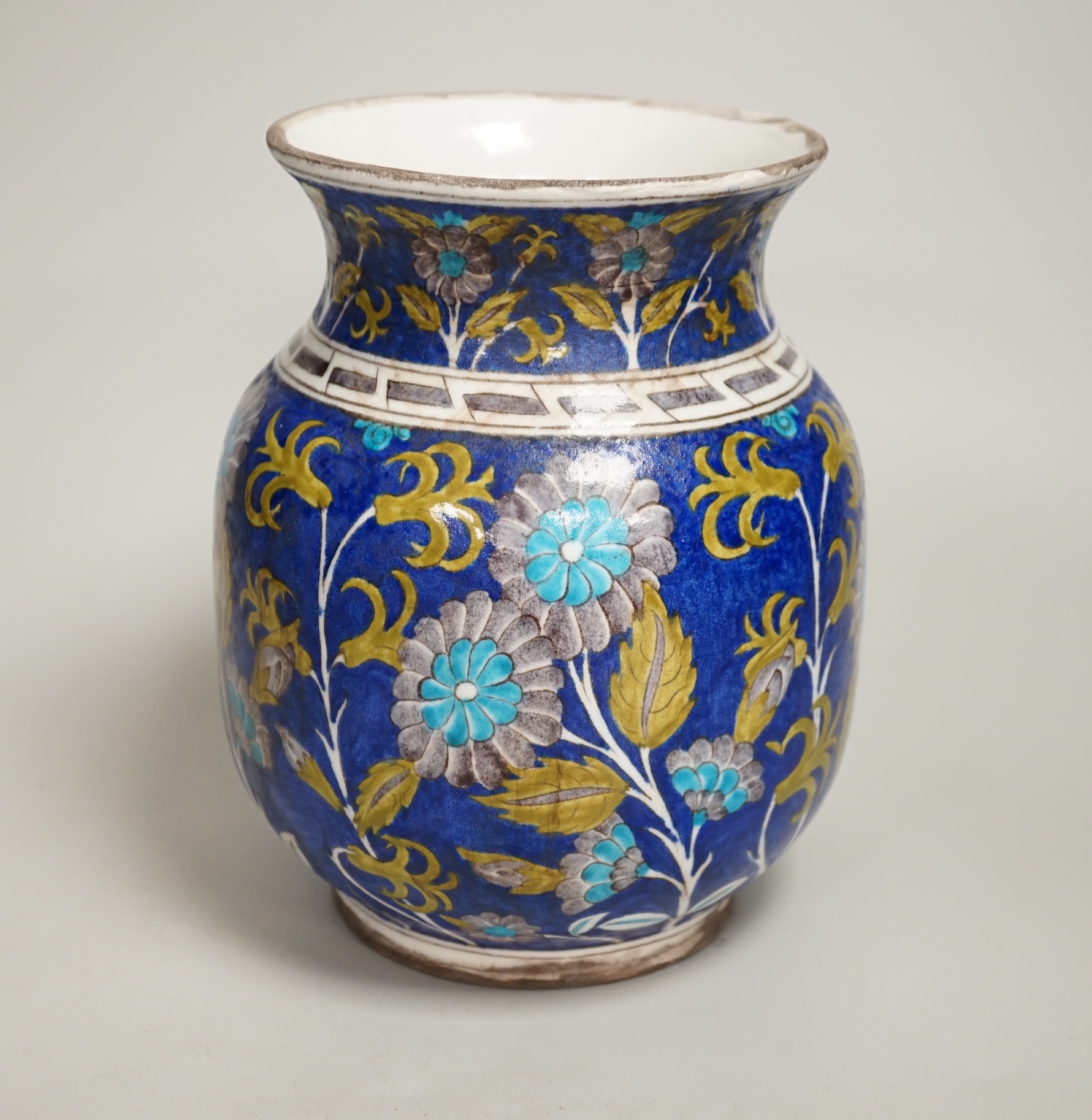 A Turkish Iznik pottery vase, decorated with flowers, 20cm high